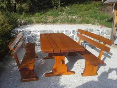 a wooden picnic table and bench on a sidewalk at Apartma Jeglic in Bohinj