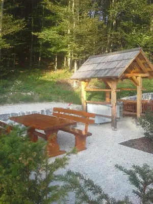 a picnic table and a gazebo in a park at Apartma Jeglic in Bohinj