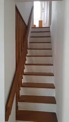 a stairway with wooden railings and white stairs at Apartma Ravbar in Kranjska Gora
