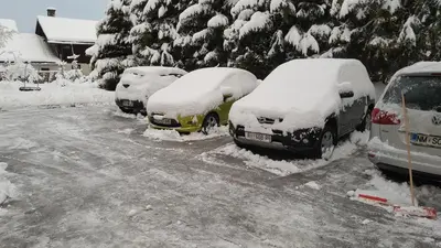 four cars parked in a parking lot covered in snow at Apartma Ravbar in Kranjska Gora