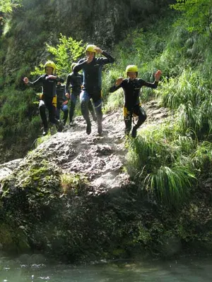 a group of people walking down a dirt path next to a river at Apartma Ravbar in Kranjska Gora