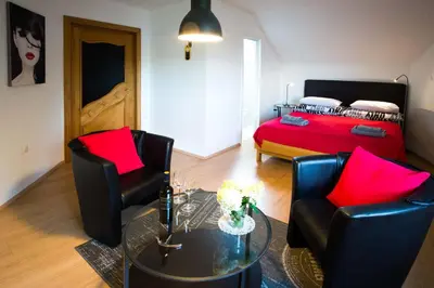 a living room with two chairs and a bed at Rooms Ambrožič in Bled