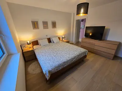 a bedroom with a bed and a flat screen tv at Hiša Pod Gozdom in Ljubljana