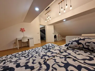a bedroom with a large bed and a desk in it at Hiša Pod Gozdom in Ljubljana