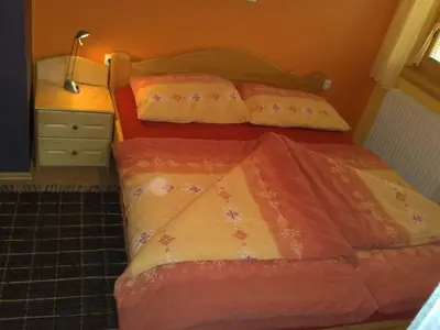 a bedroom with two beds and a dresser and a bedspread at Apartment Beli Zajec in Mozirje