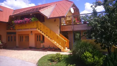 a house with a staircase and flowers on it at Apartment Beli Zajec in Mozirje