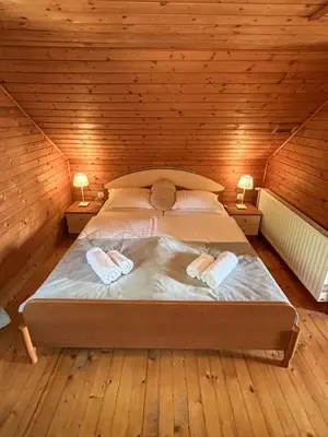 a bedroom with a large bed in a wooden room at Elton384 in Bogojina
