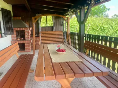 a wooden bench on a porch with a bowl of fruit at Elton384 in Bogojina