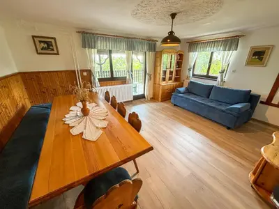 a living room with a wooden table and a blue couch at Elton384 in Bogojina