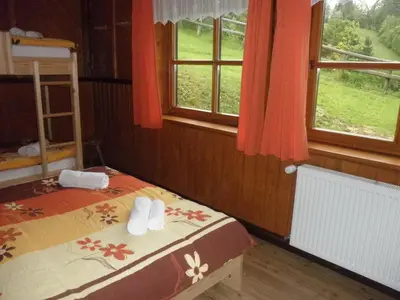 a bedroom with two beds and a window with a view at Holiday Home Čumar in Cerkno