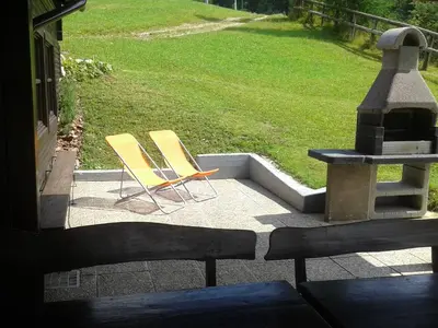two yellow chairs sitting on a patio with a grill at Holiday Home Čumar in Cerkno