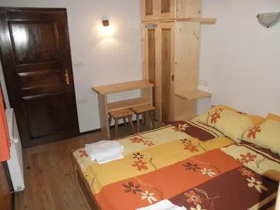 a small bedroom with a bed and a table at Holiday Home Čumar in Cerkno