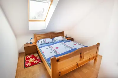 a bedroom with a wooden bed with a window at Apartments Lovec in Cerkno