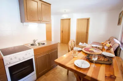 a kitchen with a wooden table with a sink and a stove at Apartments Lovec in Cerkno