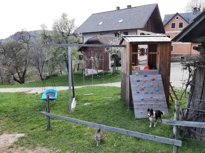 a dog is standing next to a play house at Apartments Lovec in Cerkno
