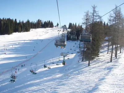 a group of people on a ski lift in the snow at Apartments Lovec in Cerkno