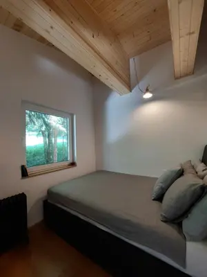 a bedroom with a bed and a window at Cottage at the lake in Preserje