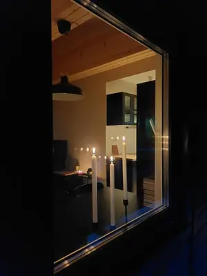 a window with three white candles in a living room at Cottage at the lake in Preserje