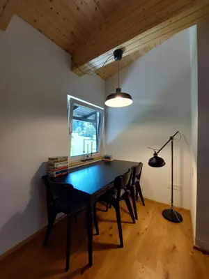 a dining room with a table and chairs and a window at Cottage at the lake in Preserje