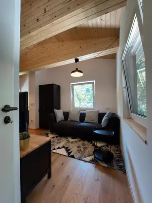 a living room with a black couch and a window at Cottage at the lake in Preserje
