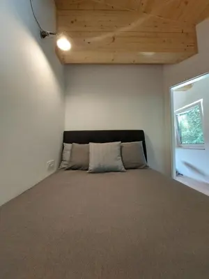 a bedroom with a large bed with a wooden ceiling at Cottage at the lake in Preserje