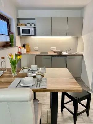 a kitchen with a wooden table and a dining room at Apartments Hana Bled in Bled