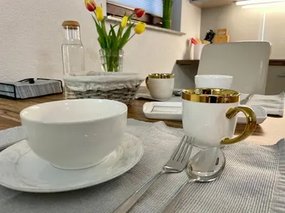 a table with two coffee cups and spoons on it at Apartments Hana Bled in Bled