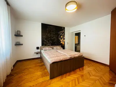 a bedroom with a bed and a black and white wall at Apartment Armic in Ljubljana