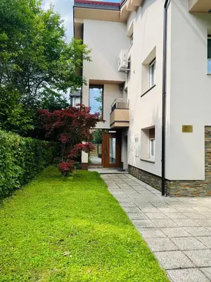 an external view of a house with a green lawn at Apartment Armic in Ljubljana