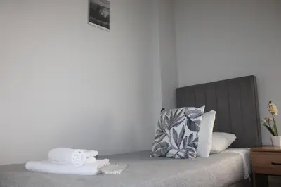 a bed with a pile of towels on top of it at Šeherezada Rooms in Ljubljana