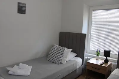 a small bedroom with a bed and a window at Šeherezada Rooms in Ljubljana