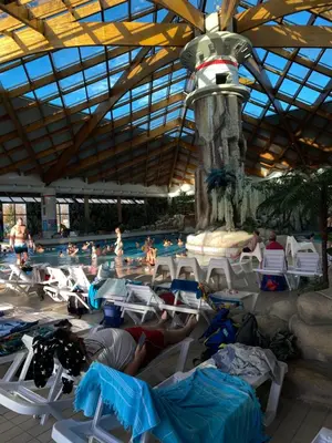 a group of people laying in chairs by a swimming pool at Hiška Nisa in Čatež ob Savi