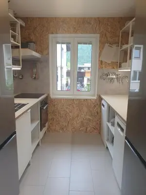 a kitchen with white counters and a window at Fully equipped SIX BEDROOM HOUSE 15 kilometers from LAKE BLED - with a terrace, garden, playground, and parking in Kropa
