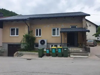 a house with four trash cans in front of it at Fully equipped SIX BEDROOM HOUSE 15 kilometers from LAKE BLED - with a terrace, garden, playground, and parking in Kropa