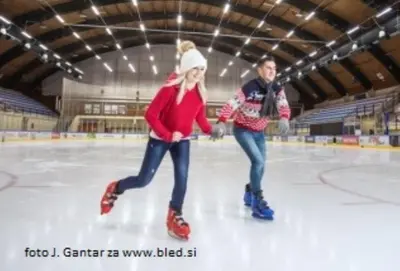 two people are skating on an ice rink at Fully equipped SIX BEDROOM HOUSE 15 kilometers from LAKE BLED - with a terrace, garden, playground, and parking in Kropa