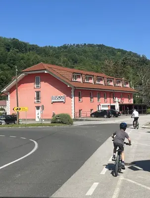 a child riding a bike down a road in front of a building at Prenočišče Buco in Krško