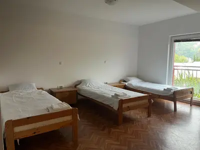 two beds in a room with a window at Prenočišče Buco in Krško