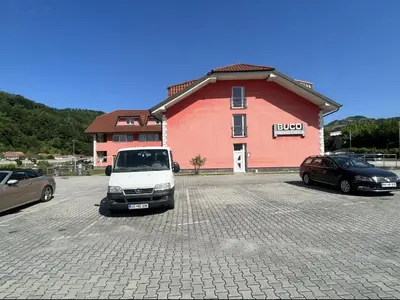 a white car parked in a parking lot in front of a building at Prenočišče Buco in Krško