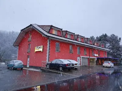 a red building with cars parked in a parking lot at Prenočišče Buco in Krško