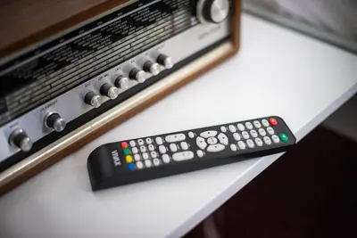 a remote control sitting on a table next to a tv at Apartma Sejalec, Lesce - Bled in Lesce