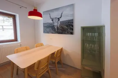 a dining room with a table and a picture of a bull at Apartma Medved - Pokljuka in Zgornje Gorje