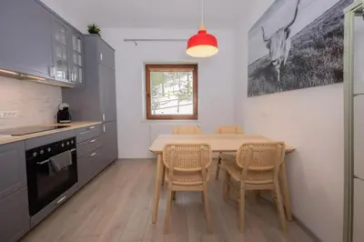 a kitchen with a table and chairs in a kitchen at Apartma Medved - Pokljuka in Zgornje Gorje