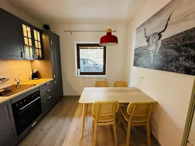 a kitchen with a table and chairs in a kitchen at Apartma Medved - Pokljuka in Zgornje Gorje