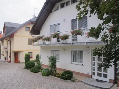 a white building with flower boxes on the balconies at Apartment Sobe Ravbar in Novo Mesto
