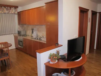 a kitchen with a desk with a television on a table at Apartment Sobe Ravbar in Novo Mesto