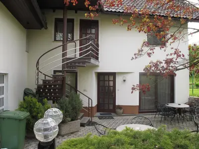 a house with a staircase and a table and chairs at Apartment Sobe Ravbar in Novo Mesto
