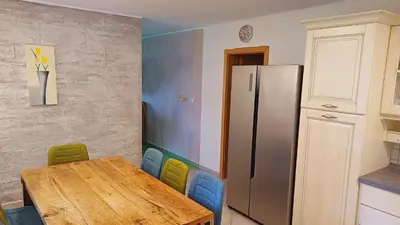 a kitchen with a wooden table and a refrigerator at Apartments Planina pod Sumikom in Planina pod Sumnikom