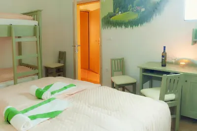 a bedroom with bunk beds and a table and chairs at Guesthouse Macesen in Spodnja Sorica