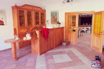 a kitchen with wooden cabinets and a table at Guesthouse Macesen in Spodnja Sorica
