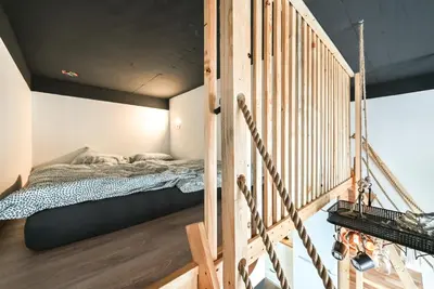 a bedroom with a bunk bed and a wooden staircase at Apartma N'Poznam župa in Ljubljana